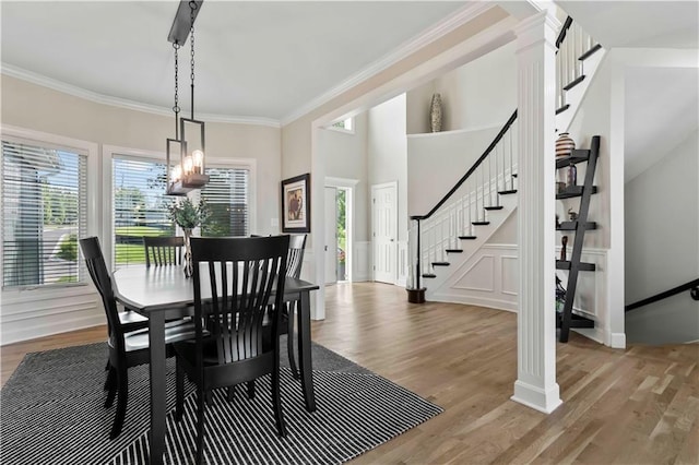 dining room with light hardwood / wood-style floors, ornamental molding, a wealth of natural light, and a chandelier