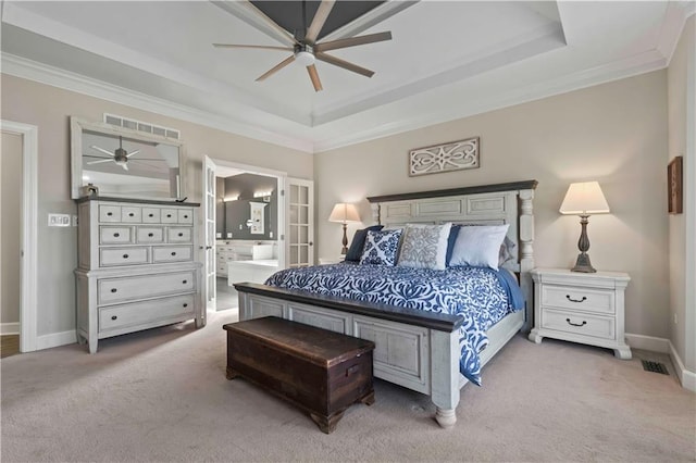 bedroom featuring ceiling fan, light colored carpet, ornamental molding, and ensuite bath