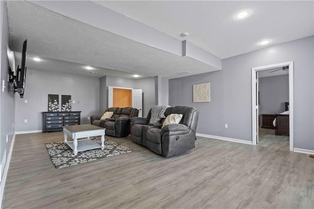 living room featuring hardwood / wood-style floors and ceiling fan