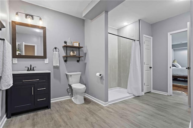 bathroom with wood-type flooring, vanity, toilet, and walk in shower