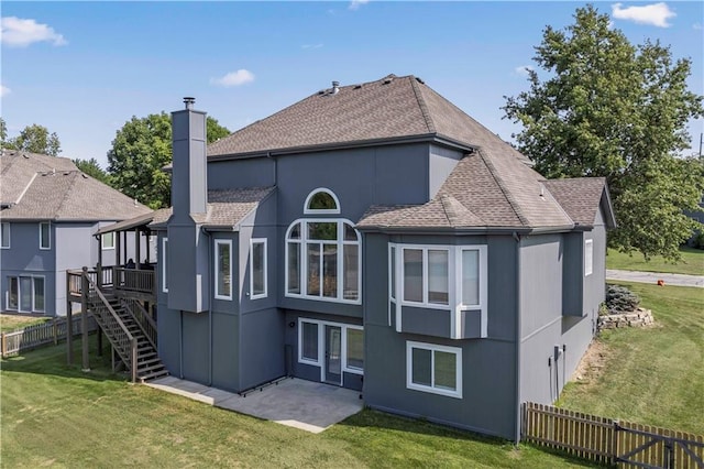 back of house featuring a lawn and a deck