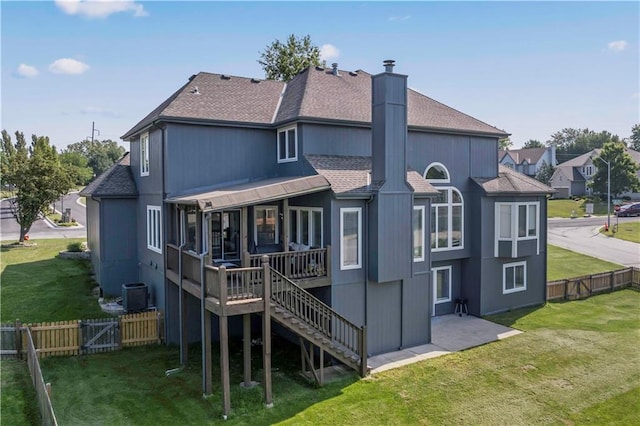 rear view of property featuring a lawn and a deck