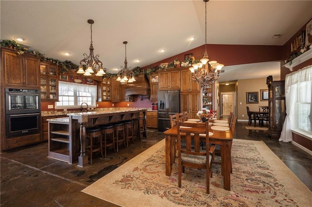 dining space featuring vaulted ceiling, an inviting chandelier, and sink