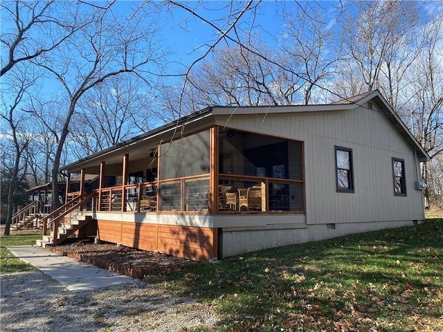 view of side of home featuring a yard and a sunroom