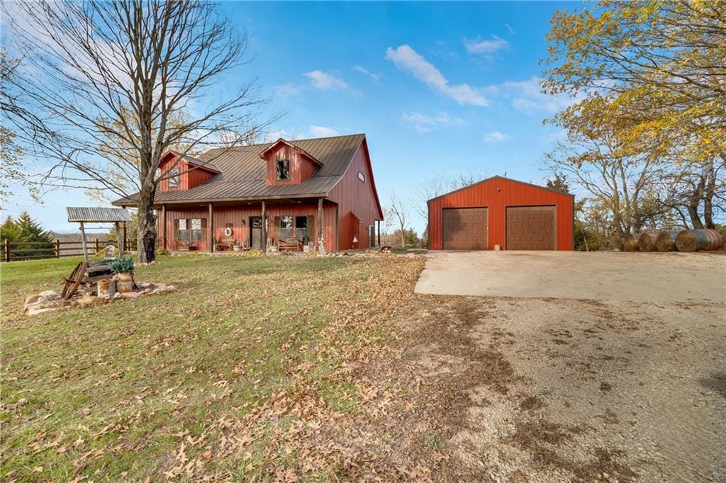 view of front of property featuring an outbuilding, a porch, a garage, and a front yard