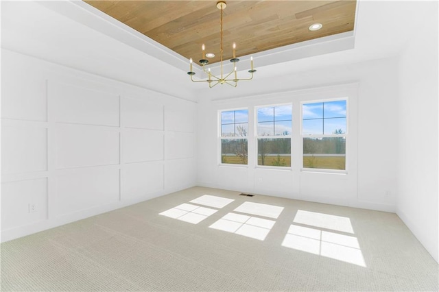 unfurnished dining area with a chandelier, a tray ceiling, wooden ceiling, and visible vents