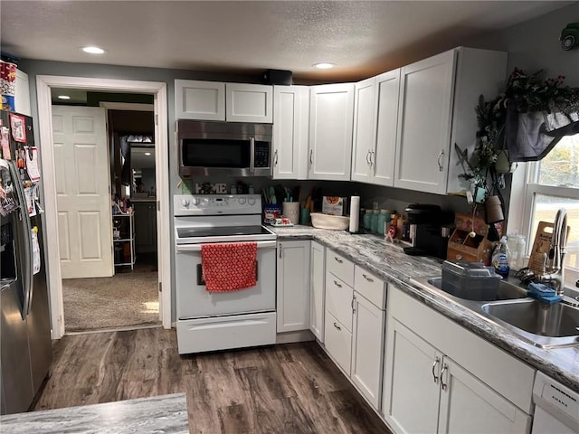 kitchen with sink, white cabinets, and white appliances