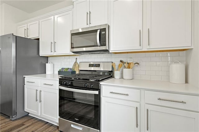 kitchen with white cabinets, decorative backsplash, stainless steel appliances, and dark hardwood / wood-style floors