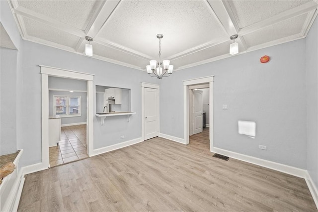 unfurnished dining area with coffered ceiling, an inviting chandelier, a textured ceiling, light wood-type flooring, and beamed ceiling