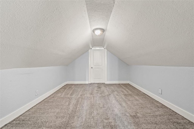 3612 College Ave, Kansas City, MO 64128 - additional living space with lofted ceiling, carpet floors, and a textured ceiling