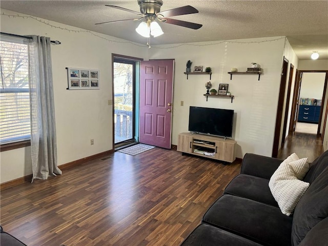 living room with ceiling fan, dark wood-type flooring, and a textured ceiling