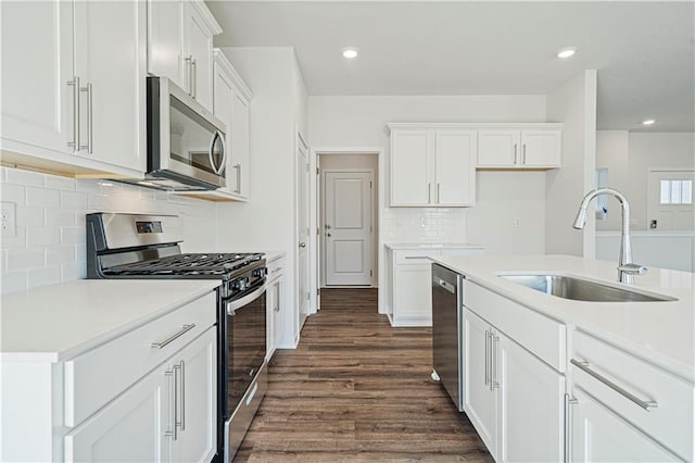 kitchen with appliances with stainless steel finishes, white cabinetry, and dark wood-type flooring