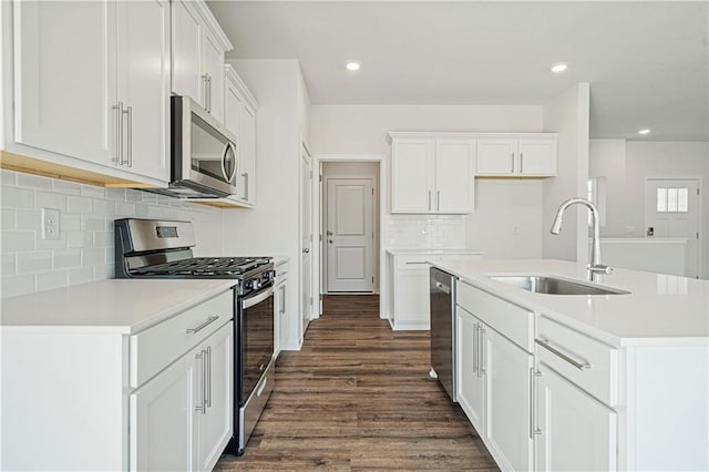 kitchen with sink, dark hardwood / wood-style floors, a kitchen island with sink, white cabinets, and appliances with stainless steel finishes