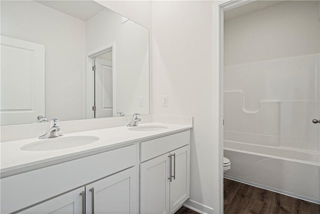 full bathroom with bathtub / shower combination, hardwood / wood-style floors, vanity, and toilet