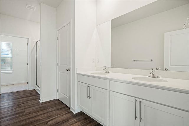 bathroom featuring hardwood / wood-style floors, vanity, and an enclosed shower