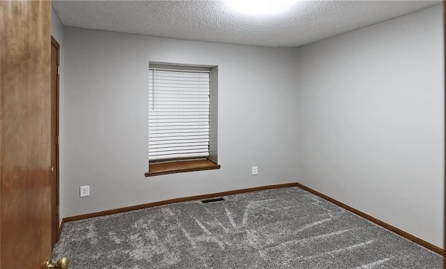 carpeted spare room featuring a textured ceiling