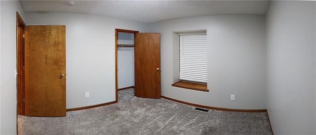 unfurnished bedroom featuring a closet, light colored carpet, and a textured ceiling