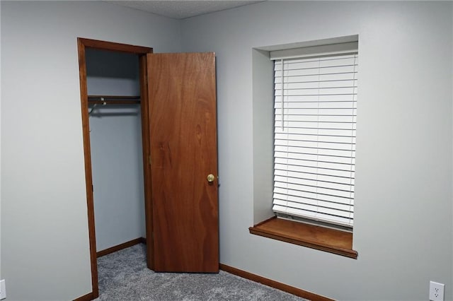 unfurnished bedroom featuring a closet, carpet, and a textured ceiling