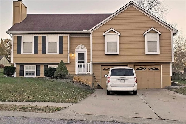 split foyer home with a front lawn and a garage