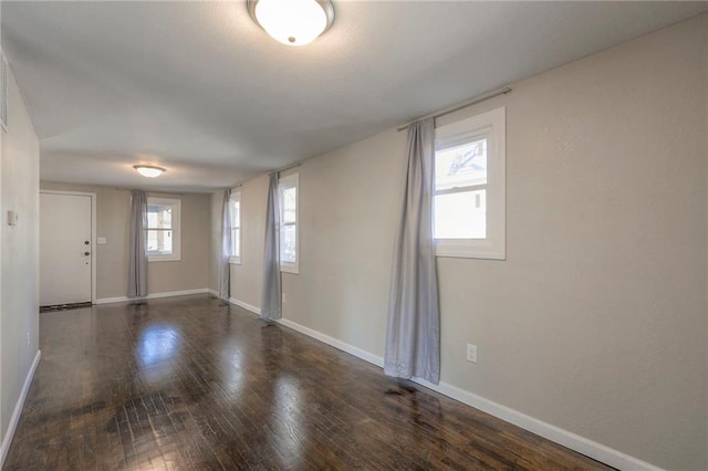 spare room with a healthy amount of sunlight and dark hardwood / wood-style flooring