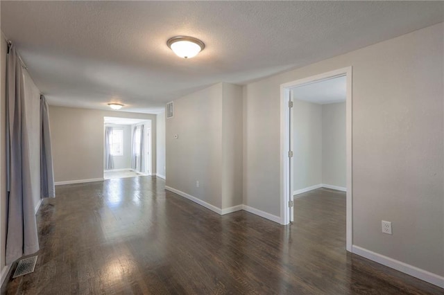 unfurnished room featuring a textured ceiling and dark wood-type flooring