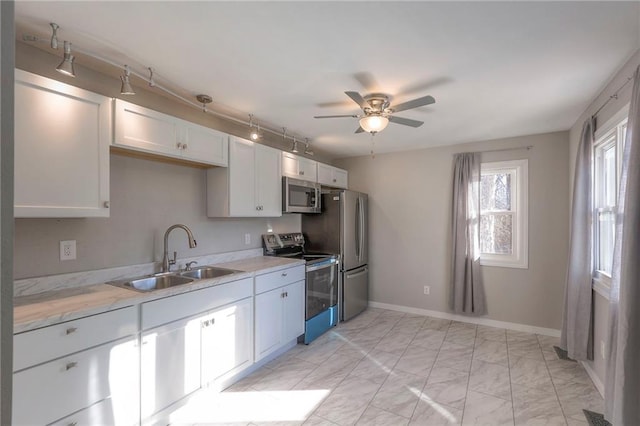 kitchen featuring white cabinetry, sink, ceiling fan, and appliances with stainless steel finishes