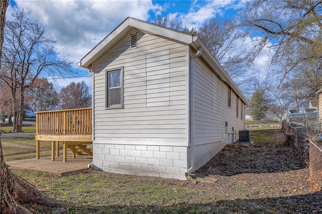 view of side of home featuring a wooden deck, a patio, and central AC