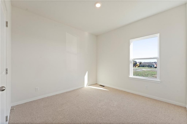 spare room featuring light colored carpet