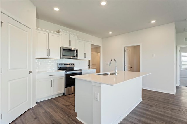 kitchen with sink, dark hardwood / wood-style floors, a center island with sink, white cabinets, and appliances with stainless steel finishes