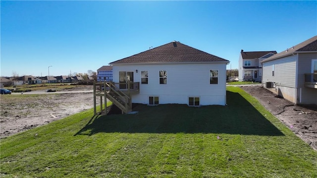 back of property with central AC unit, stairs, and a yard