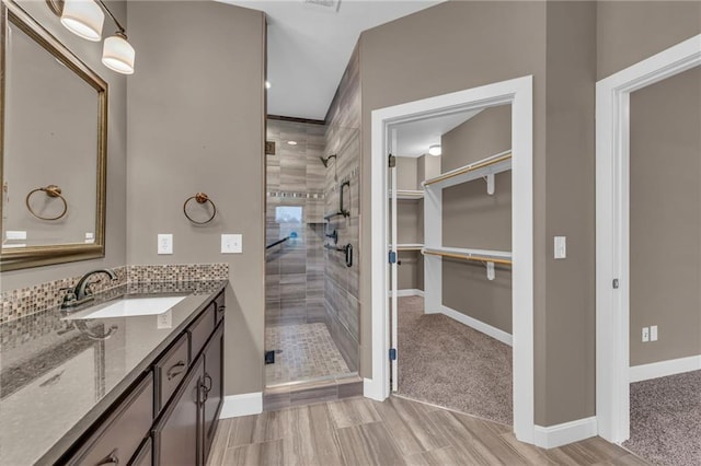 bathroom with hardwood / wood-style floors, vanity, and a shower with shower door