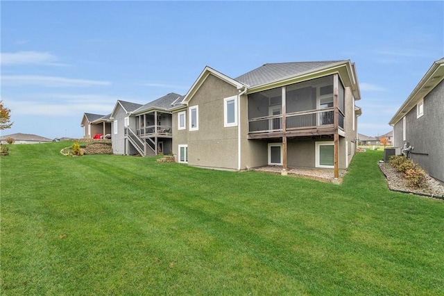 back of property with a yard, central AC unit, and a sunroom