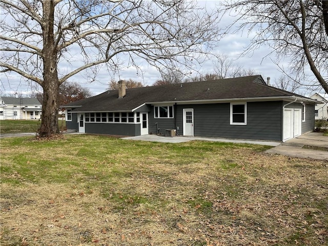 rear view of house featuring a lawn, cooling unit, a garage, and a patio