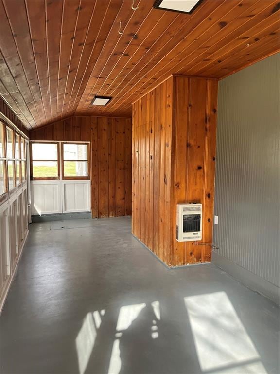 interior space featuring concrete flooring, heating unit, vaulted ceiling, and wood ceiling