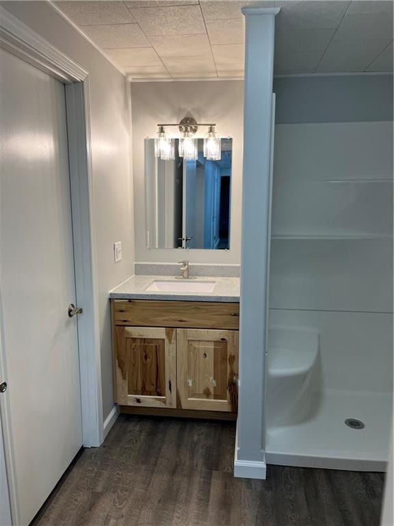 bathroom featuring a shower, hardwood / wood-style floors, and vanity