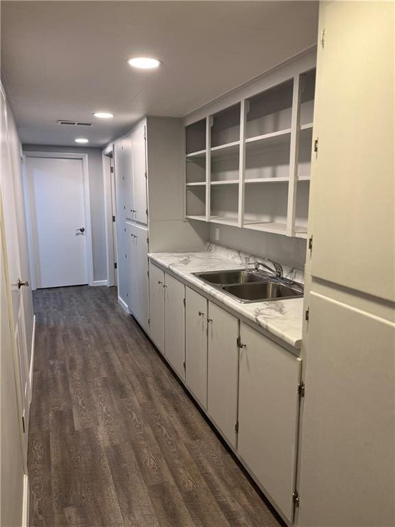 kitchen featuring white cabinets, dark hardwood / wood-style flooring, white fridge, and sink