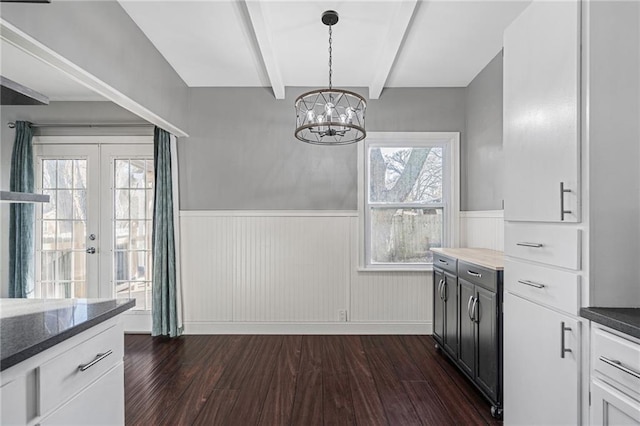 kitchen with french doors, white cabinets, beamed ceiling, decorative light fixtures, and dark hardwood / wood-style flooring