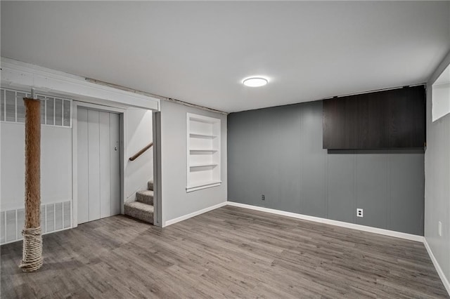 basement with hardwood / wood-style flooring and built in features