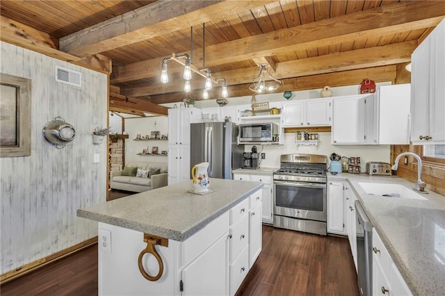 kitchen featuring a center island, wooden ceiling, beamed ceiling, white cabinetry, and stainless steel appliances