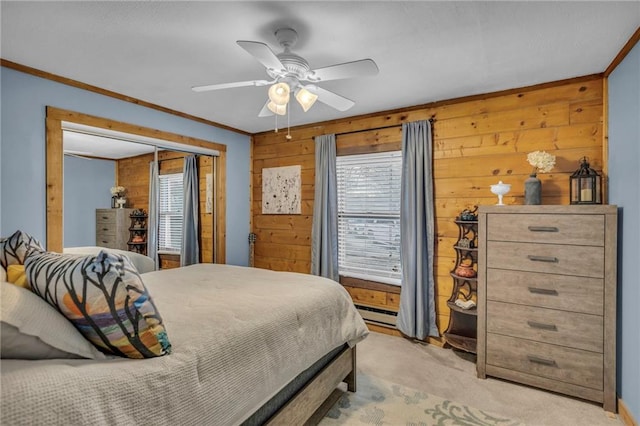 carpeted bedroom with a closet, multiple windows, ceiling fan, and wooden walls