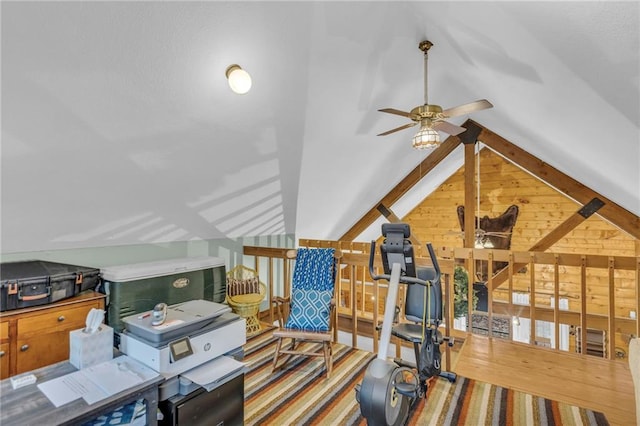 exercise room featuring hardwood / wood-style floors, vaulted ceiling, ceiling fan, and wood walls