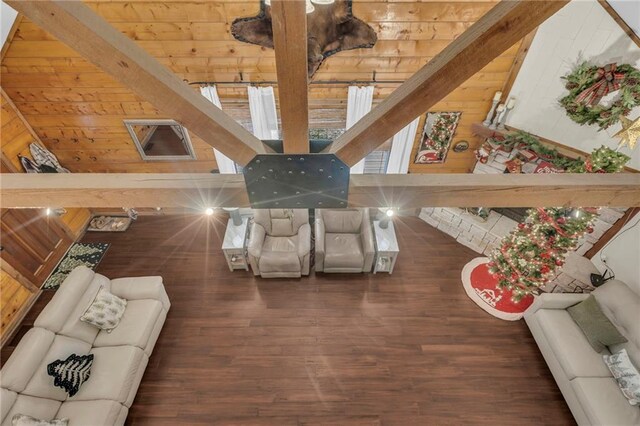 living room featuring wood walls, dark hardwood / wood-style flooring, beamed ceiling, and wooden ceiling