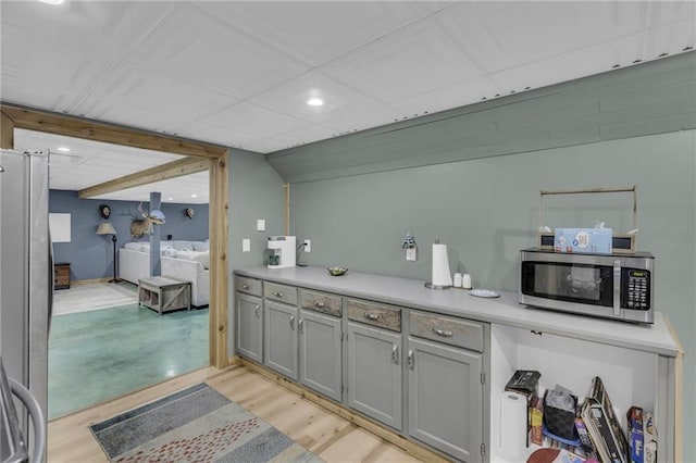 kitchen featuring light wood-type flooring, stainless steel appliances, and gray cabinets