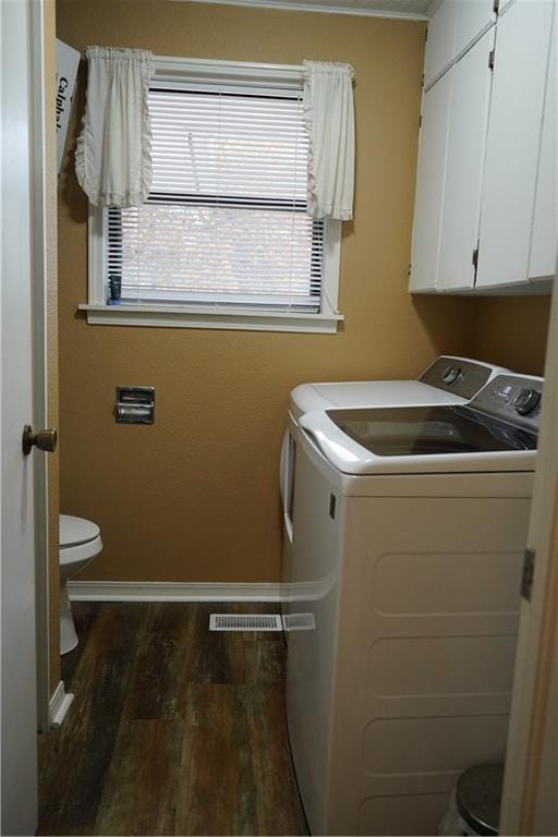 clothes washing area with dark hardwood / wood-style floors and washing machine and clothes dryer