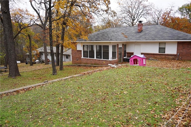 back of property featuring a sunroom and a yard