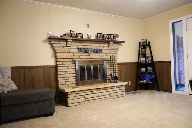 carpeted living room featuring a textured ceiling, a stone fireplace, crown molding, and wooden walls