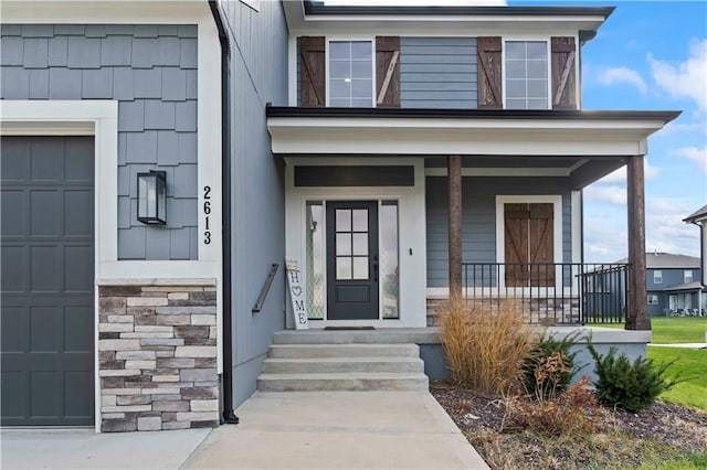 doorway to property with a porch and a garage