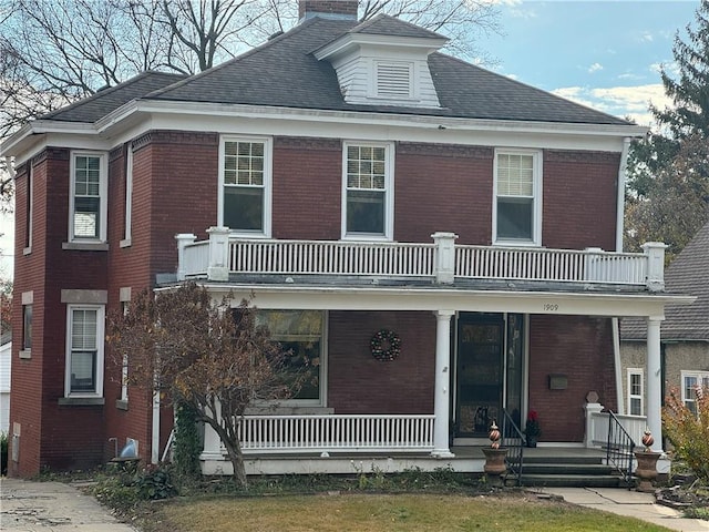 view of front facade featuring covered porch and a balcony