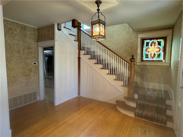 interior space featuring wood-type flooring and crown molding