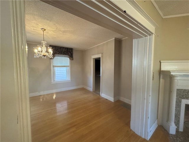 interior space with crown molding, a chandelier, a textured ceiling, and hardwood / wood-style flooring